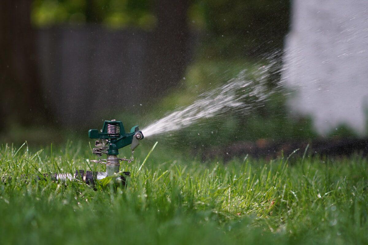 Residential irrigation sprinkler running on a lawn — a common source of water damage when systems malfunction near Idaho Falls homes